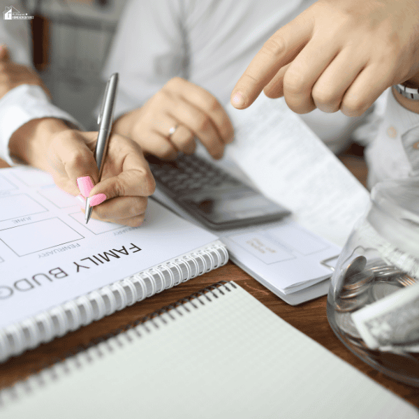 Family reviewing household expenses, receipts, and a monthly spending plan to find simple ways to save money and manage their budget.