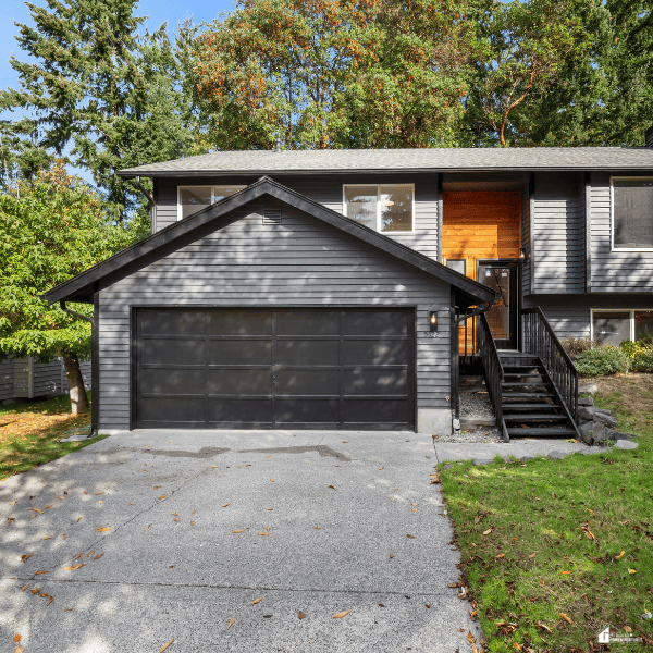 Modern home with a double garage door and concrete driveway, highlighting residential garage door maintenance and curb appeal.