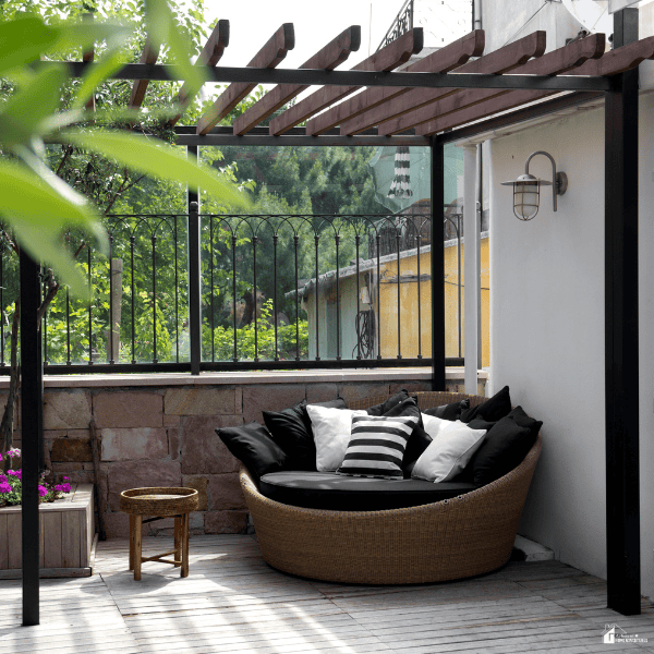 Cozy covered backyard seating area with comfortable outdoor furniture designed for relaxing and spending more time outside.