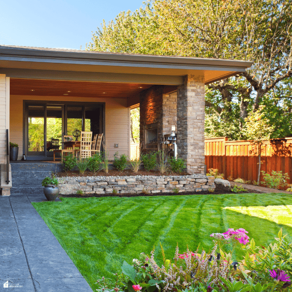Landscaped backyard with a covered patio and green lawn creating a functional outdoor living space for family gatherings.