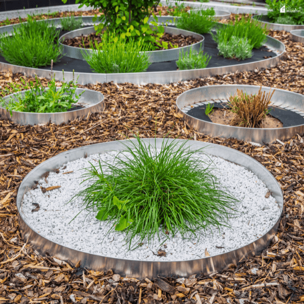 Circular garden beds with decorative materials and ornamental plants showcase a creative outdoor home project.
