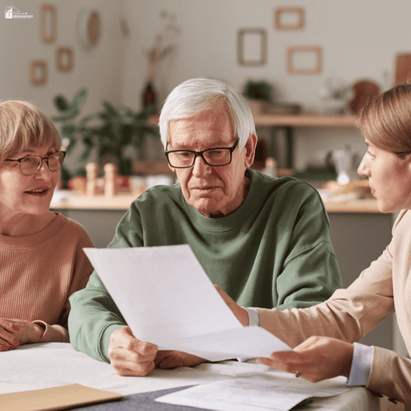 Older adults reviewing will and succession planning documents with a professional to organize future asset distribution.