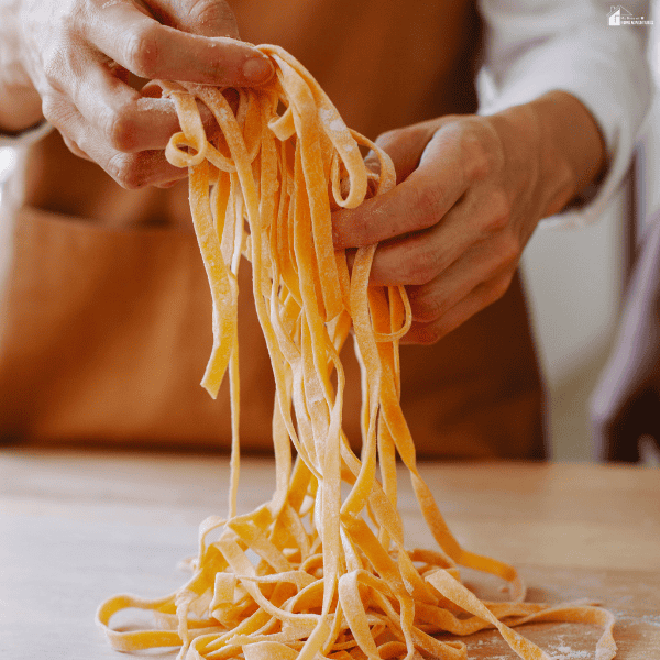 Fresh handmade pasta strands being prepared by hand, highlighting the craftsmanship and quality standards that define authentic Italian restaurants.