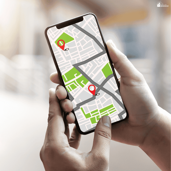 Person uses a smartphone map to search nearby rental properties and compare available homes.
