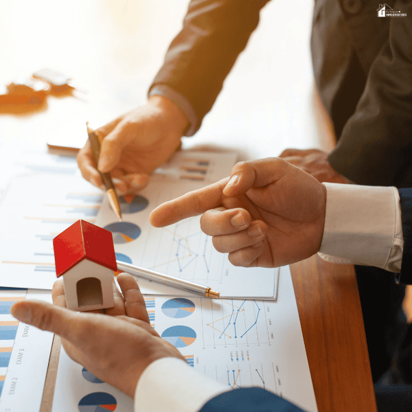 Business professionals reviewing property documents and financial charts while discussing a cost segregation strategy for real estate investments.