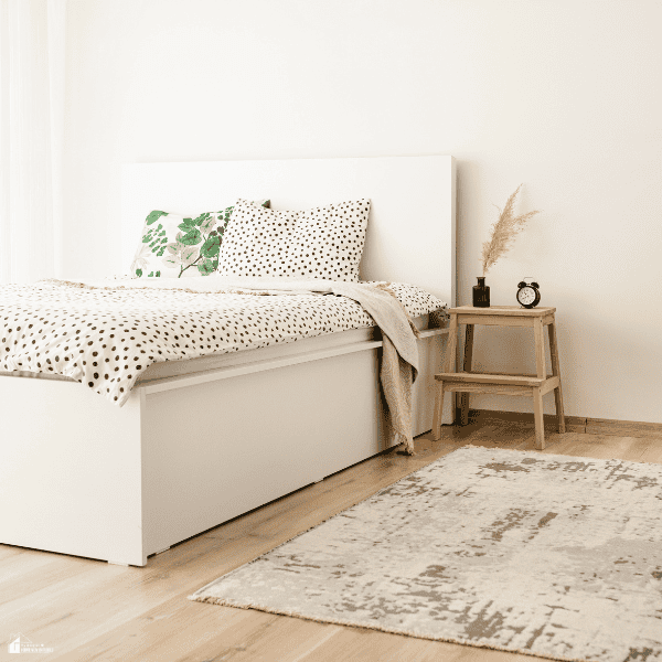 Minimalist bedroom with cozy bedding, a soft area rug, and simple décor, creating a comfortable retreat during the colder season.