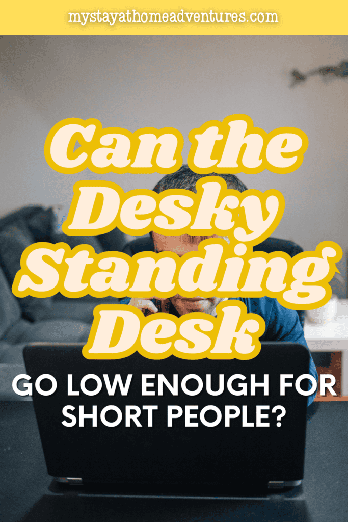 A person works at an adjustable standing desk set to a comfortable height, showing an ergonomic workspace for shorter users.