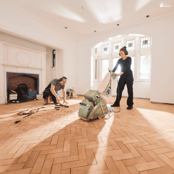 Contractors restore a hardwood floor after indoor flooding, showing cost-effective home water damage repair and restoration work.