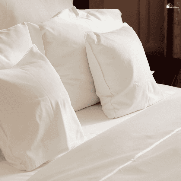 Neatly arranged white shams and pillowcases create a clean, layered bedding look with a soft and elegant finish.