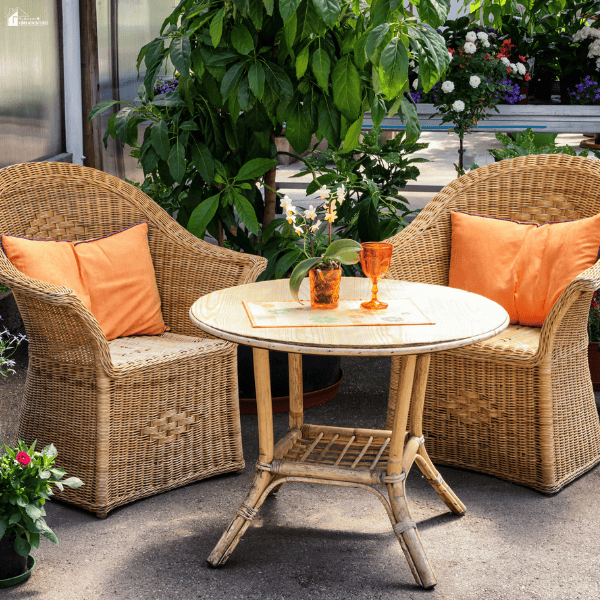 Inviting outdoor seating area with woven chairs, a round table, and decorative touches that create a luxurious patio for relaxing and entertaining.