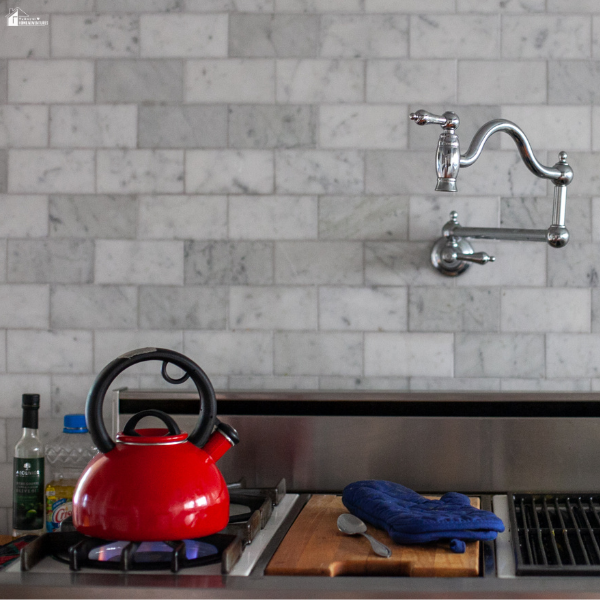 Modern kitchen with a wall-mounted pot filler above the stove, highlighting a functional luxury home upgrade that improves everyday cooking.