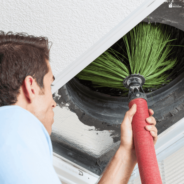 Professional duct cleaner removing dust and debris from residential air ducts to improve indoor air quality.