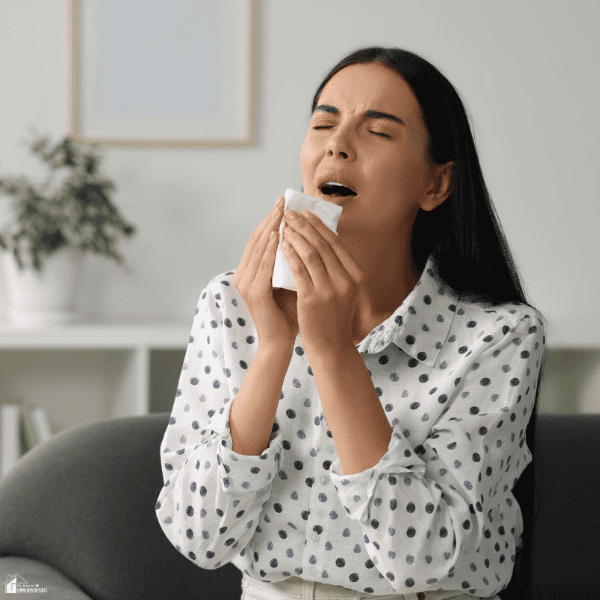 Person experiencing allergy symptoms that may indicate it is time to hire a professional duct cleaner.