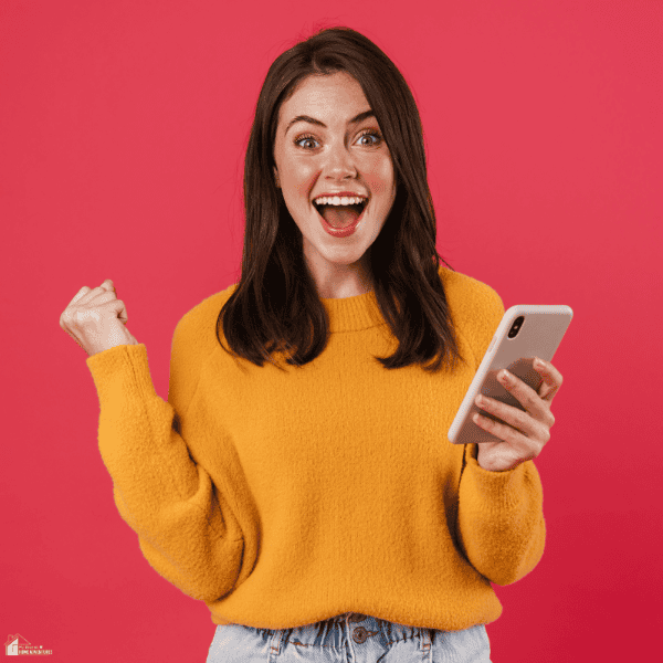 Smiling woman holding a smartphone with an excited expression, representing the fun of playing free online card games.