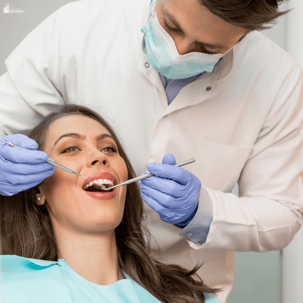 Dentist examining a patient's teeth during a routine dental checkup to support lifelong oral health.