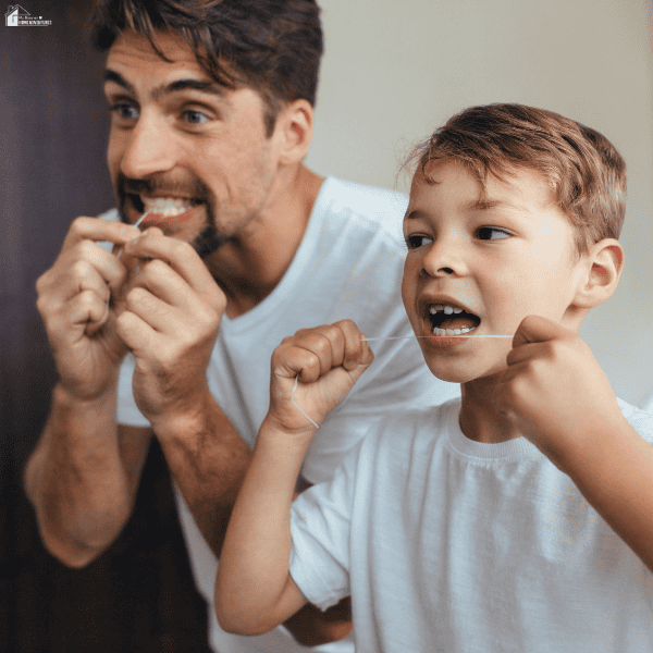 Parent and child flossing their teeth together to build healthy dental habits as a family.