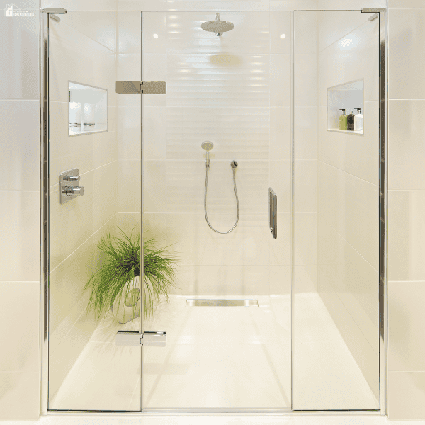 A modern walk-in shower features a frameless glass enclosure, built-in wall niches, and a sleek linear drain for a contemporary bathroom design.