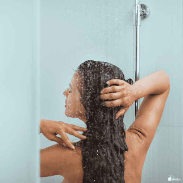 A person enjoys a spacious walk-in shower with a glass enclosure, highlighting comfort and modern bathroom functionality.