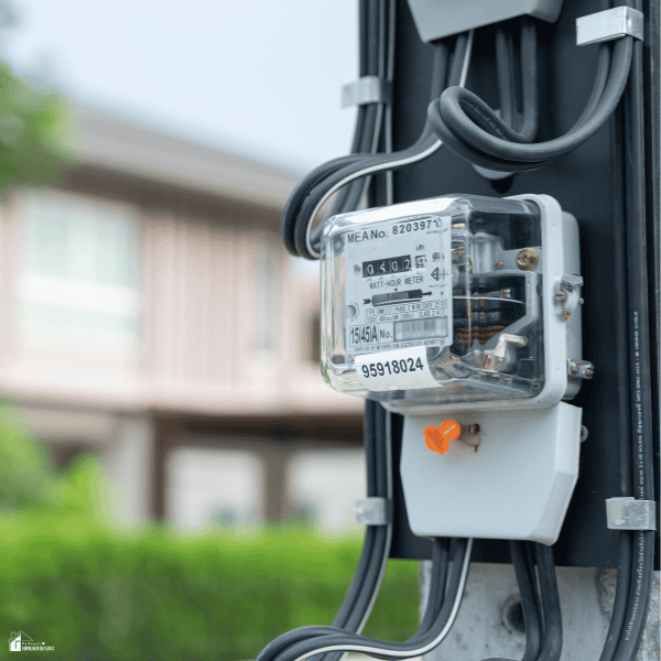 Close-up of a residential electric meter connected to a home's power supply, representing electricity usage monitoring and rising utility costs.