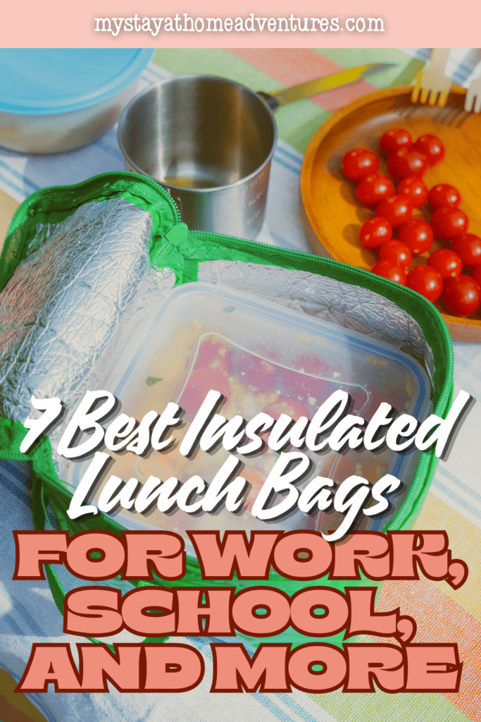 Open green insulated lunch bag with a food container inside, surrounded by a metal cup, tomatoes, and meal prep supplies.