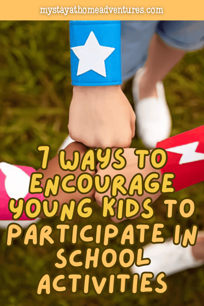 Young children stack their hands together outdoors in a teamwork gesture that represents encouragement, participation, and involvement in school activities.