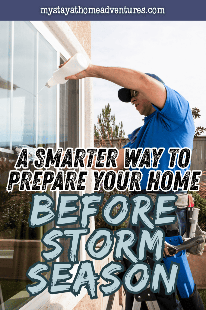 Worker sealing the exterior of a home window to help protect against wind and water damage before severe storms arrive.