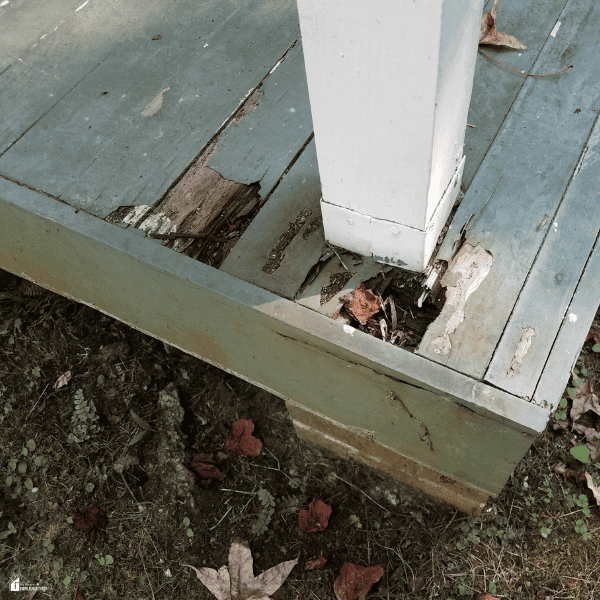 Damaged wooden deck boards with visible rot around a support post, showing deterioration that proper deck waterproofing can help prevent.