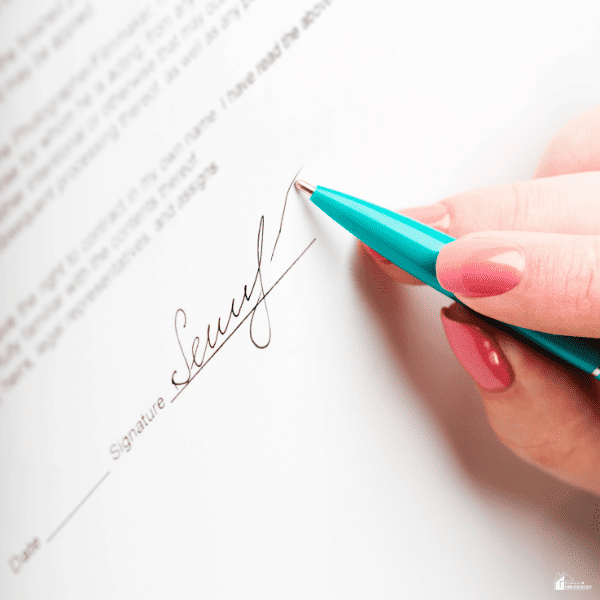 Close-up of a person signing a homeschool diploma with a pen, highlighting the signature section used to complete the document.