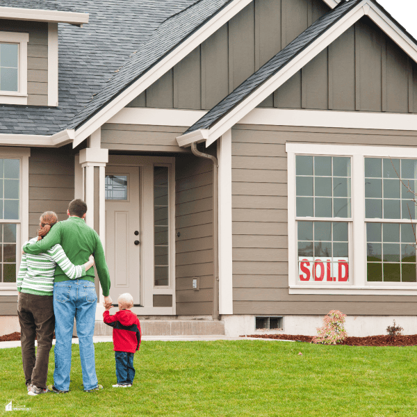 Family standing together outside a newly purchased home, representing the decision to sell a house after making repairs.