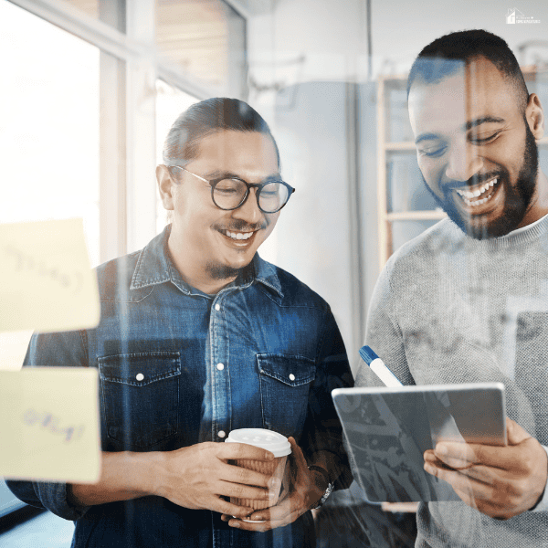 Two coworkers review a tablet together, illustrating a discussion about SEO engagement goals and results.