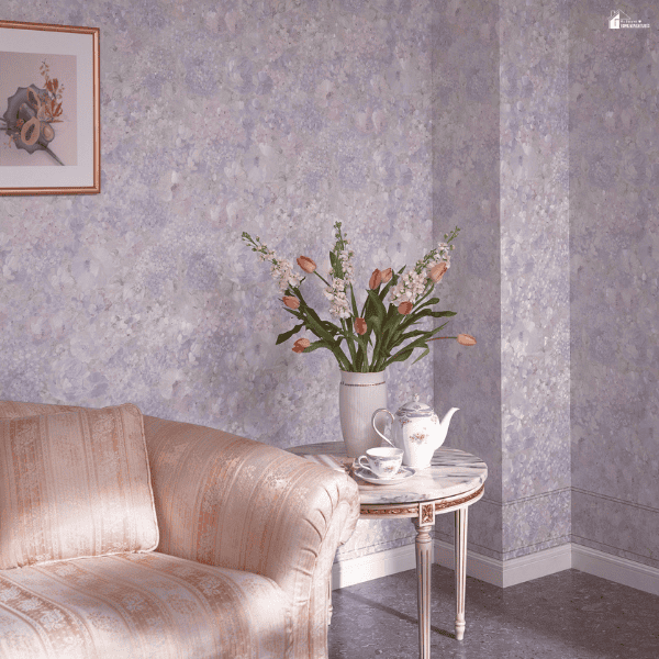 Soft purple flower prints cover the wall beside a pale pink sofa and a vase of tulips.