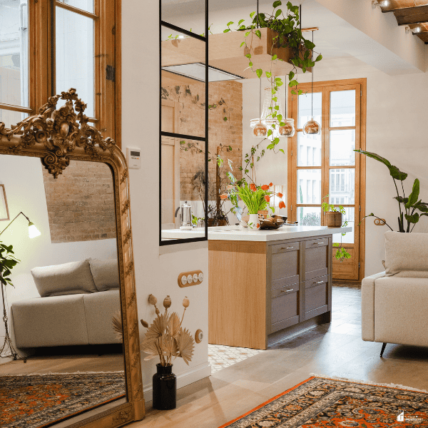 Bright small living space with a kitchen, seating area, plants, rugs, and a large mirror, showing multiple surfaces and areas that benefit from deep cleaning.