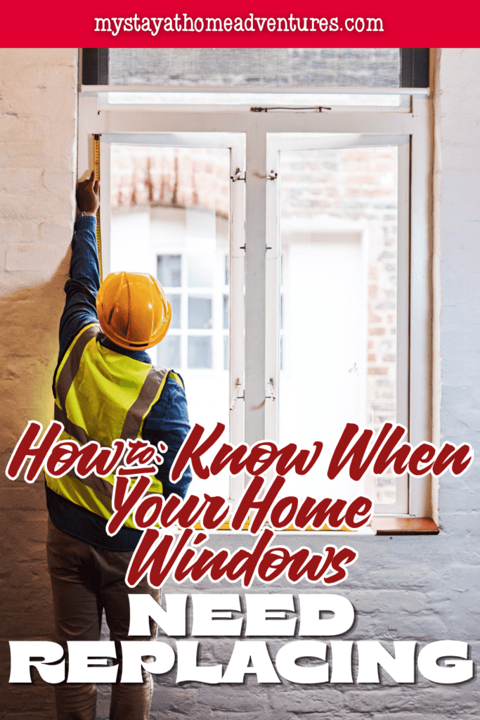 A worker measures a home window opening before installing a new window.