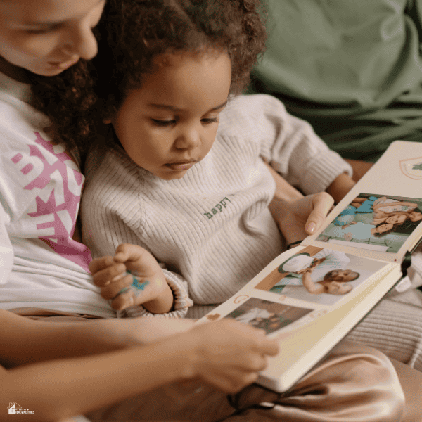 Parent and young child sharing family memories while looking through a treasured photo album together.