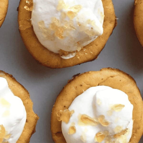 Mini Pumpkin Cheesecakes: Small pumpkin cheesecakes are topped with whipped cream and golden caramel crunch pieces.
