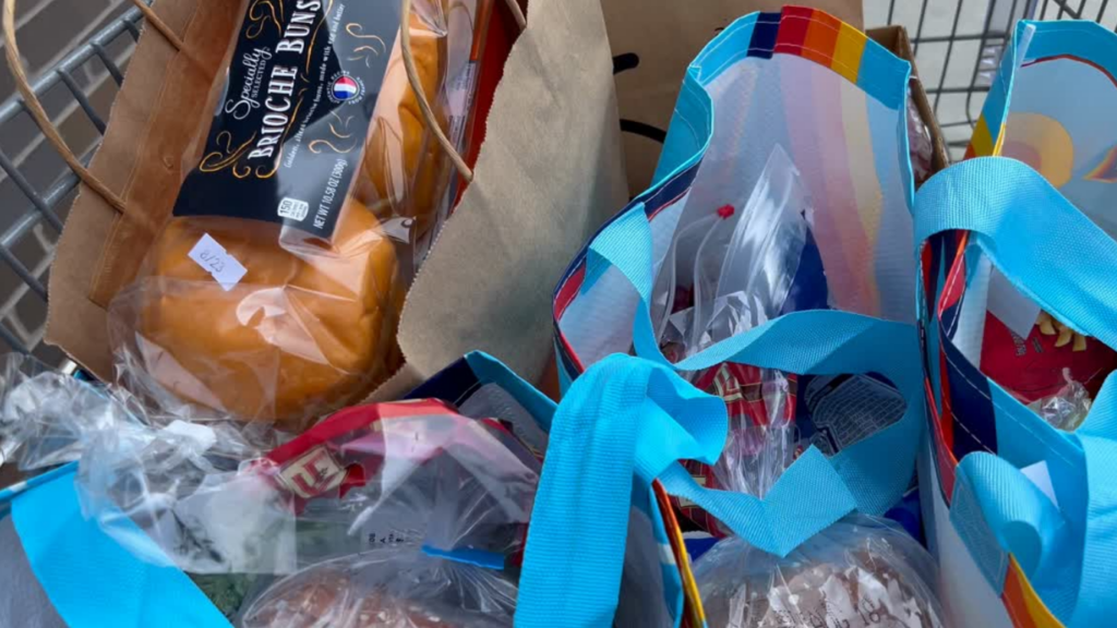Reusable grocery bags and bread in a shopping cart during a September grocery trip while tracking grocery spending and monthly food costs.