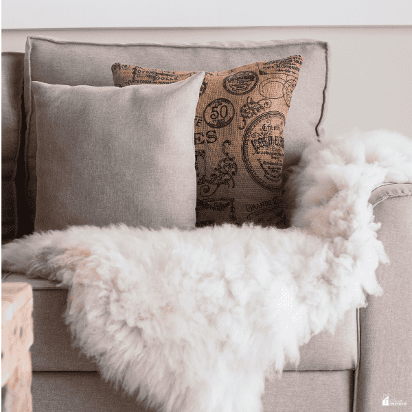 Cozy sofa with soft pillows and a fluffy throw, showing simple home upgrades that add warmth, texture, and comfort to a living space.