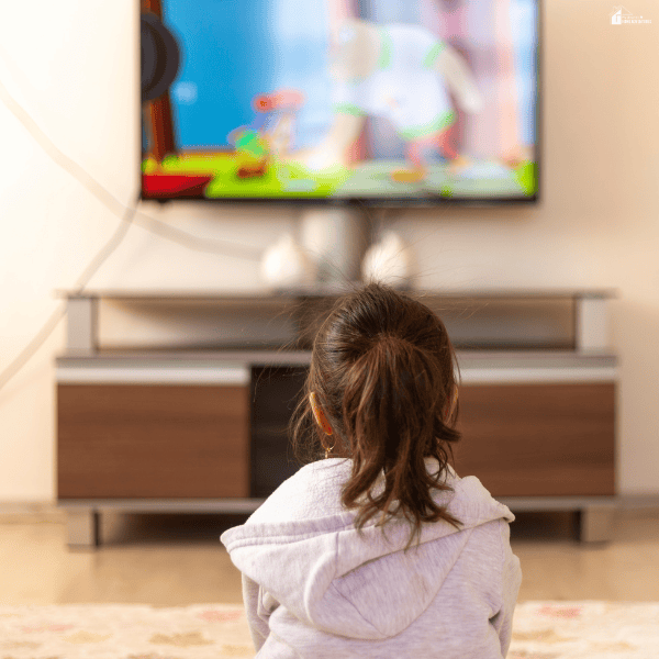 A young girl watches an animated movie, illustrating how TV ratings help families choose age-appropriate entertainment.