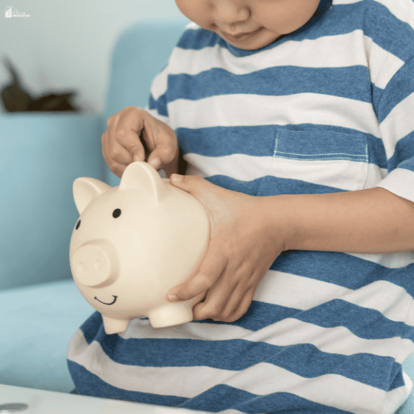 A child places a coin in a piggy bank to practice saving as part of money management.
