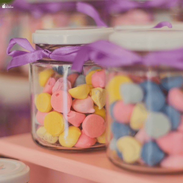 Colorful candy jars tied with purple ribbons as sweet treats for adding to personalized gift boxes for family and friends.