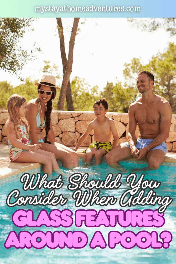 A family of four sits at the edge of a pool with their feet in the water.