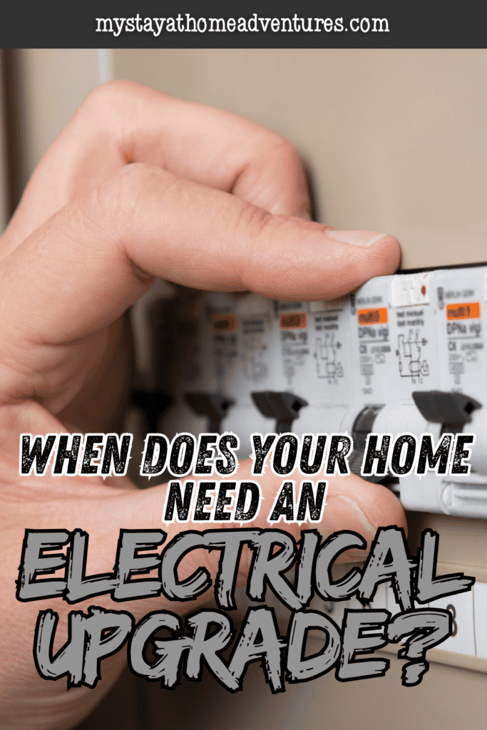 A hand touches a row of circuit breakers, highlighting the panel involved in a home electrical upgrade.