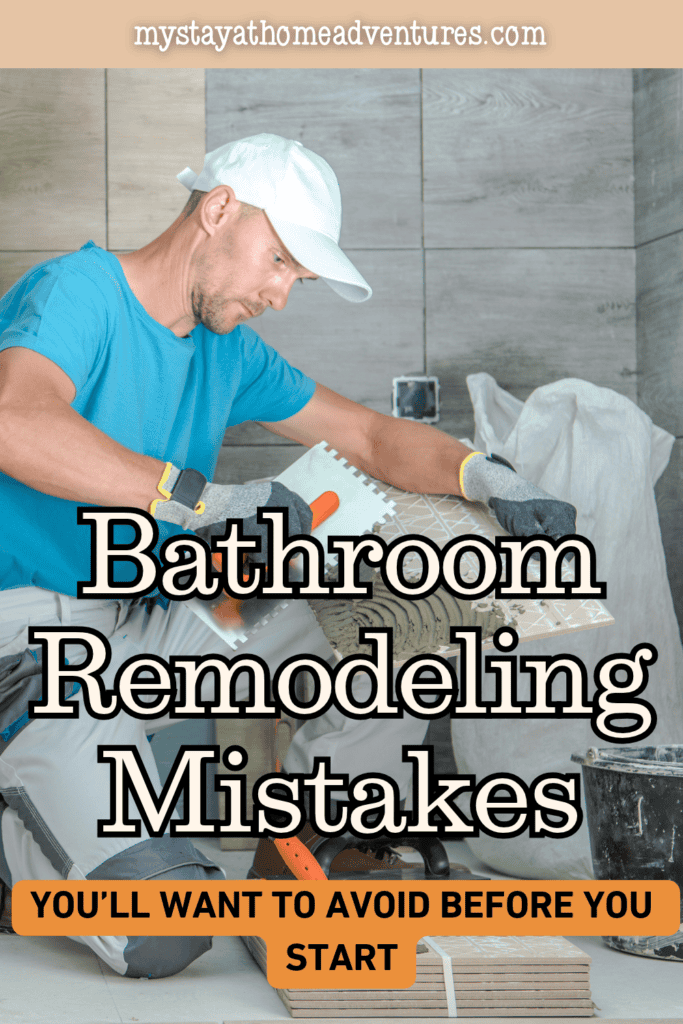 A worker spreads adhesive across the back of a tile during a bathroom renovation.