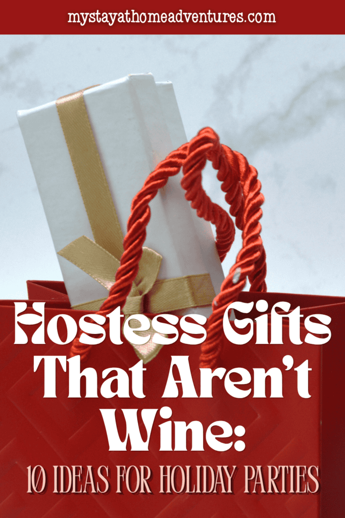 A white present tied with gold ribbon sits inside a red bag, showing a festive way to package hostess gifts.