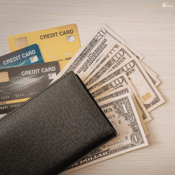 A black wallet, banknotes, and payment cards illustrate budgeting considerations related to early paycheck access.