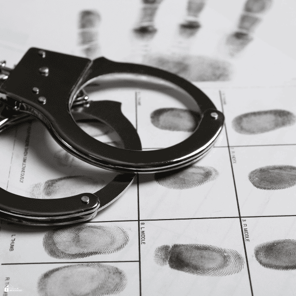 Metal handcuffs rest on a fingerprint record, illustrating detention concerns related to deportation cases.