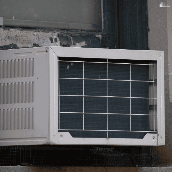 A window air conditioner with a protective metal grille highlights equipment that needs regular home cooling maintenance.