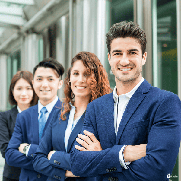 Four smiling professionals in business suits stand outside an office building, illustrating opportunities for a high-paying career.